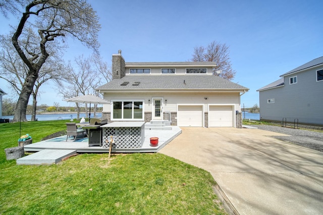 view of front of house with a garage, a front lawn, a deck with water view, a chimney, and driveway