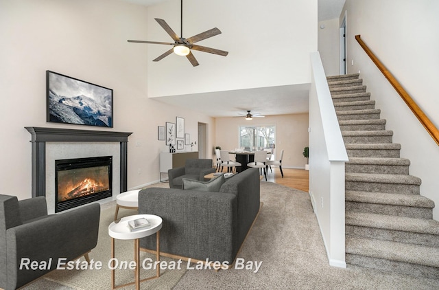 living room with a towering ceiling and ceiling fan