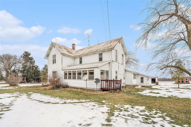 snow covered property with a sunroom and a yard