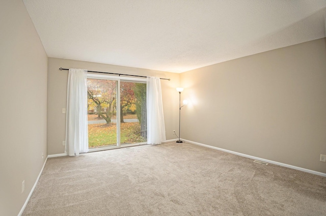 carpeted spare room with a textured ceiling