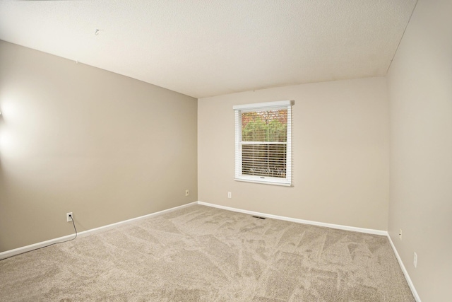 carpeted spare room with a textured ceiling