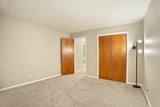 unfurnished bedroom featuring light colored carpet, a closet, and a textured ceiling