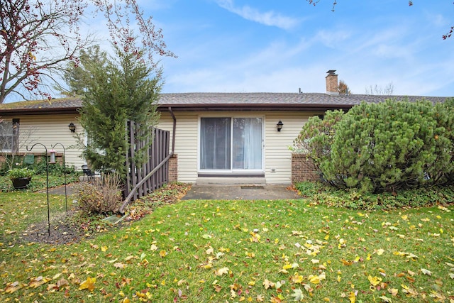 rear view of property with a yard