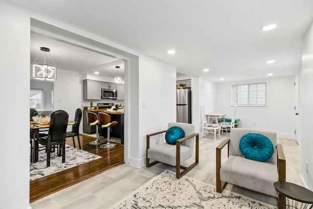 living area featuring light wood-style flooring, baseboards, and recessed lighting