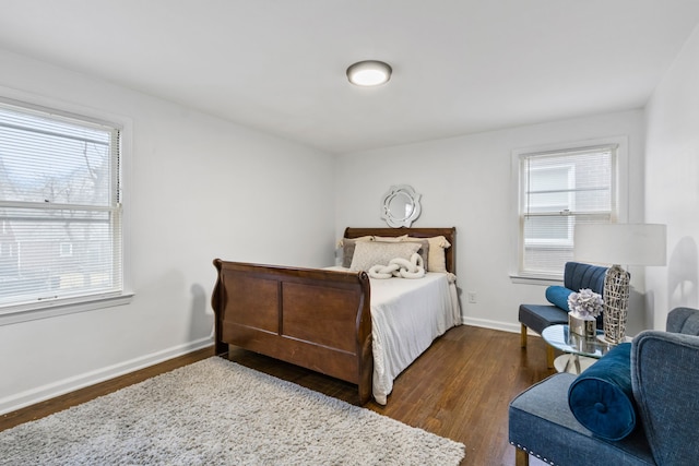 bedroom featuring multiple windows, baseboards, and wood finished floors