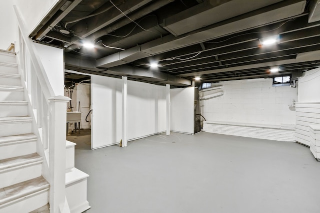 finished basement featuring a sink and stairway