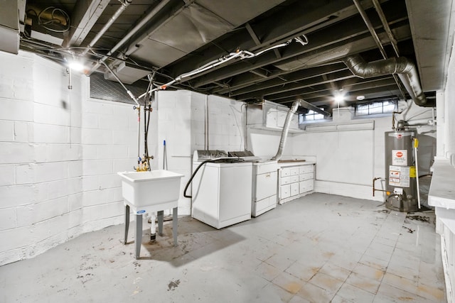 basement featuring gas water heater, a sink, and washing machine and clothes dryer