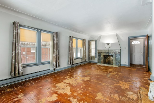 unfurnished living room featuring a baseboard radiator and a tiled fireplace