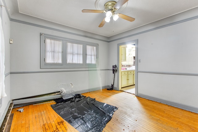 exercise room with light wood-type flooring and ceiling fan