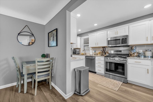 kitchen featuring backsplash, white cabinets, and appliances with stainless steel finishes