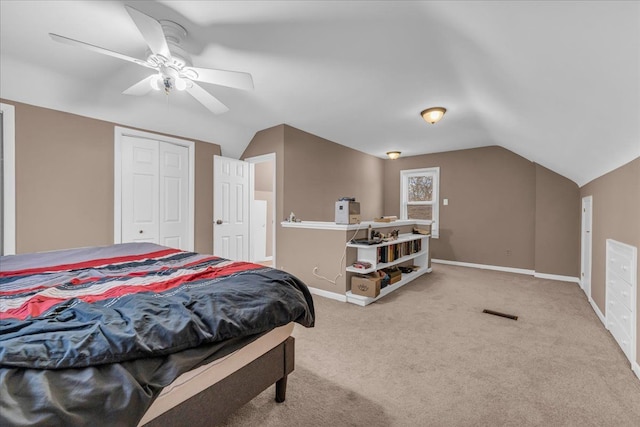 carpeted bedroom with vaulted ceiling, a closet, and ceiling fan