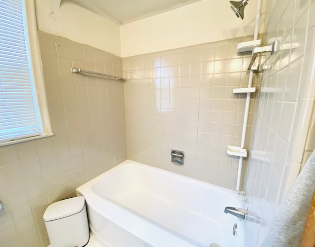 bathroom with toilet and tiled shower / bath combo