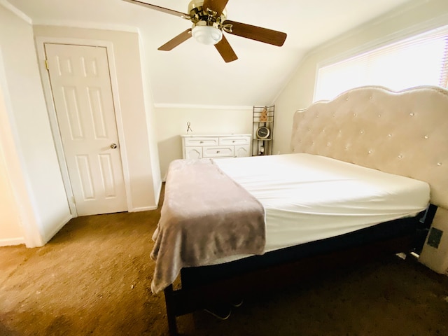 bedroom with ceiling fan, carpet flooring, and vaulted ceiling