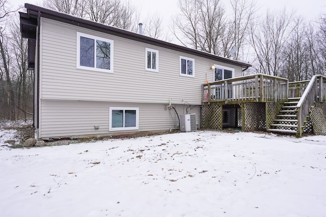 snow covered rear of property featuring a deck