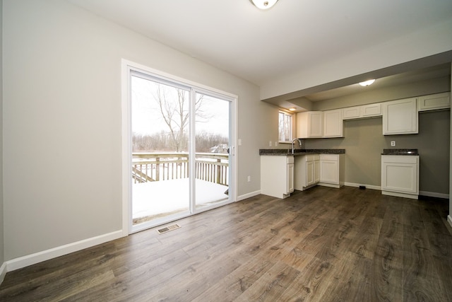 kitchen with white cabinetry, sink, and dark hardwood / wood-style floors