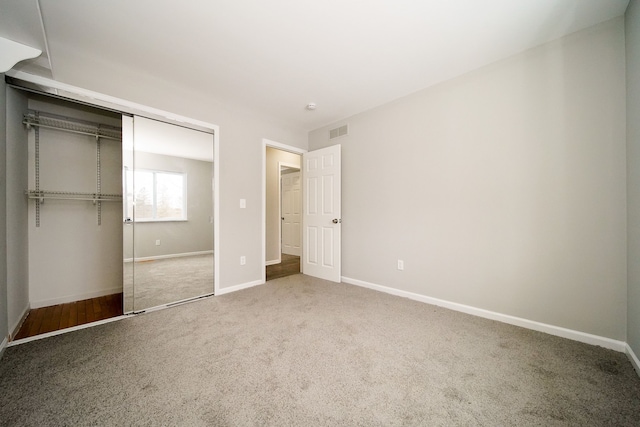 unfurnished bedroom with carpet floors and a closet