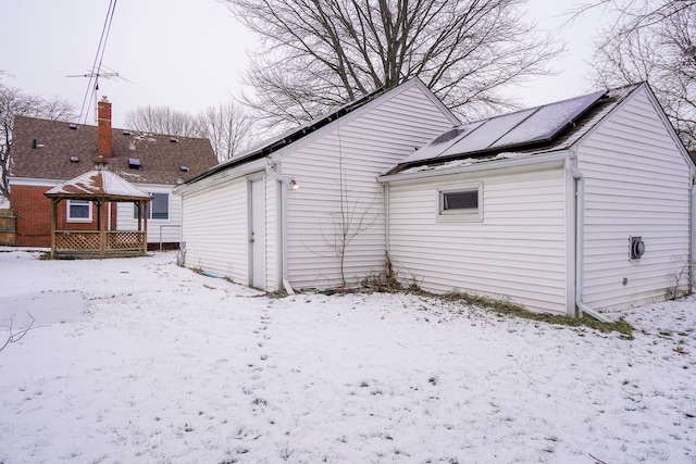 snow covered house with solar panels