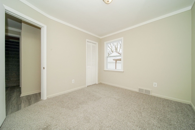 unfurnished bedroom featuring ornamental molding, carpet flooring, and a closet