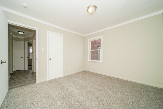 unfurnished room with ornamental molding and light colored carpet