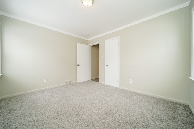 spare room with crown molding and carpet floors