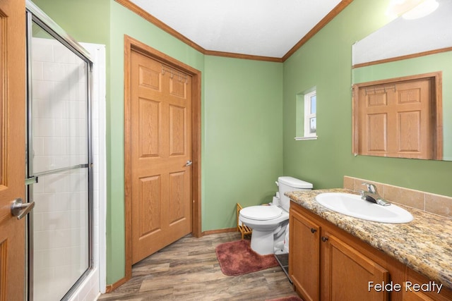 bathroom featuring hardwood / wood-style flooring, vanity, ornamental molding, toilet, and walk in shower