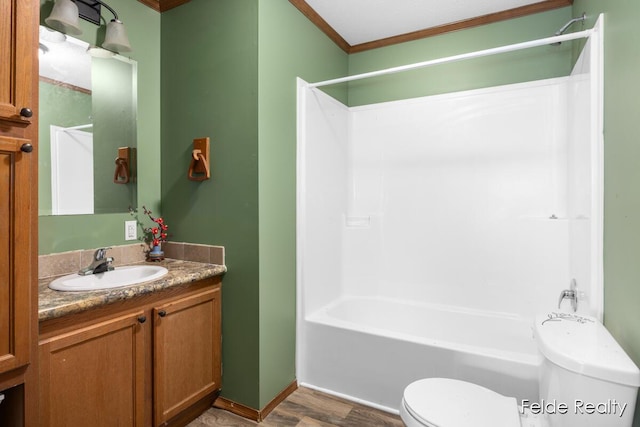 full bathroom with toilet, wood-type flooring, shower / bathtub combination, ornamental molding, and vanity