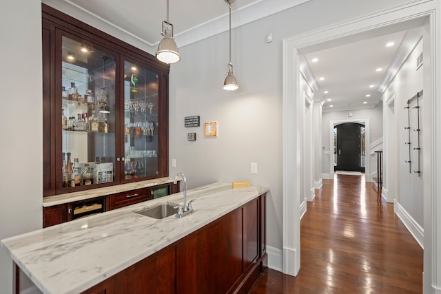 bar with recessed lighting, a sink, hanging light fixtures, indoor wet bar, and dark wood finished floors