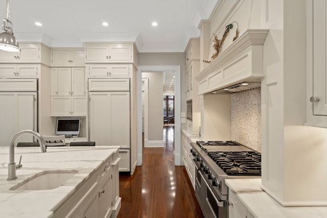 kitchen featuring light stone counters, pendant lighting, dark wood-style flooring, a sink, and high quality appliances