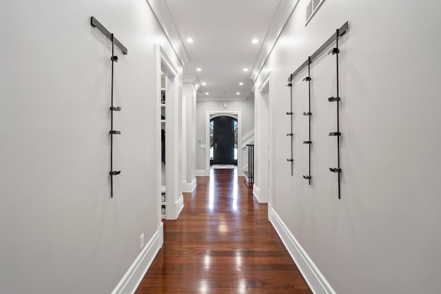 hall with arched walkways, dark wood-style flooring, recessed lighting, ornamental molding, and baseboards