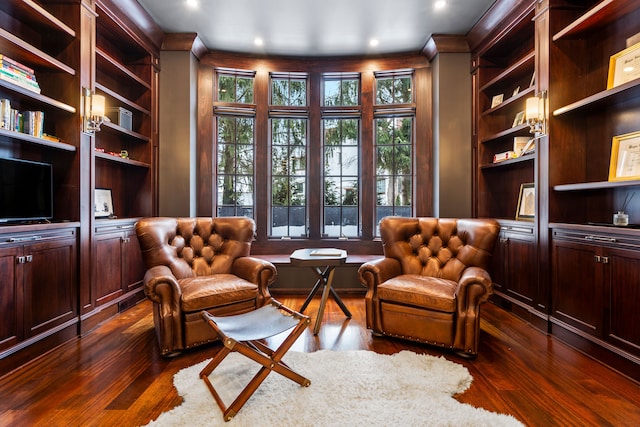 living area featuring visible vents, built in features, and dark wood-style flooring