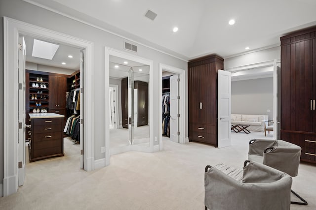 spacious closet featuring lofted ceiling with skylight, visible vents, and light colored carpet