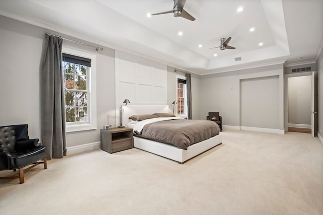 bedroom featuring a raised ceiling, visible vents, ornamental molding, light carpet, and baseboards