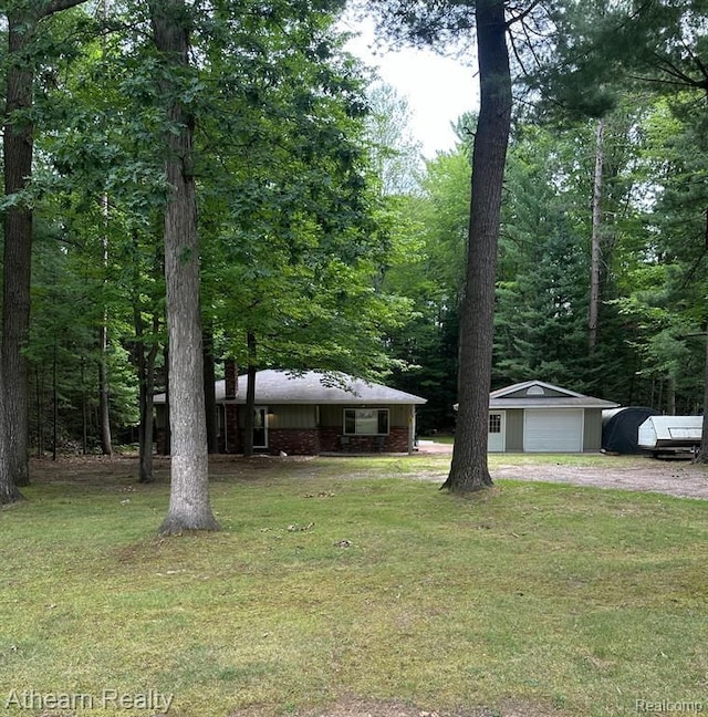 view of front of house featuring an outbuilding, a garage, and a front lawn