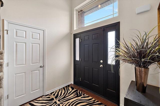 entryway with dark wood finished floors and baseboards