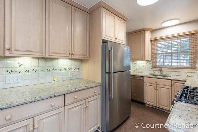 kitchen with appliances with stainless steel finishes, sink, decorative backsplash, light stone countertops, and light brown cabinets