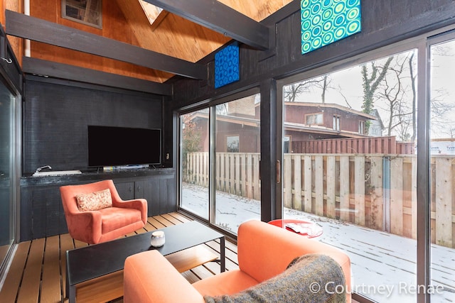 sunroom featuring beam ceiling and a skylight