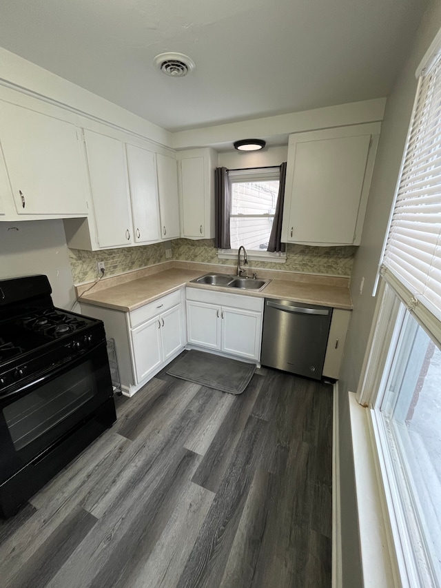 kitchen featuring stainless steel dishwasher, black gas range, sink, white cabinetry, and dark hardwood / wood-style floors