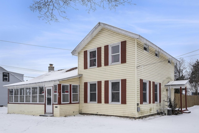 view of front facade featuring a sunroom and central AC unit