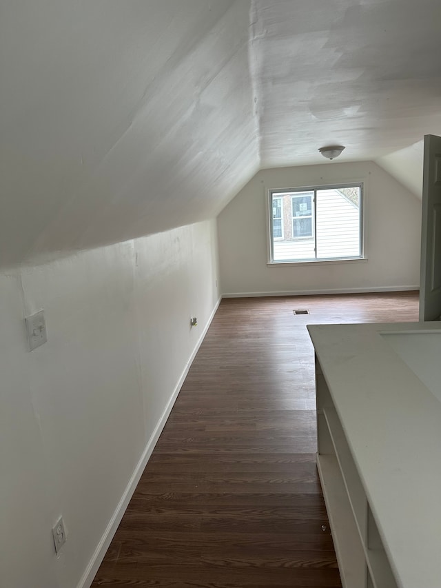 bonus room featuring vaulted ceiling and dark hardwood / wood-style flooring