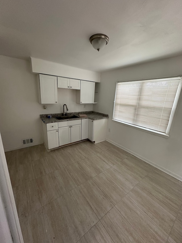 kitchen with white cabinetry and sink