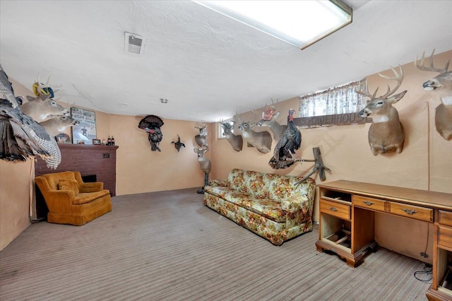 basement with a brick fireplace, light colored carpet, and a textured ceiling