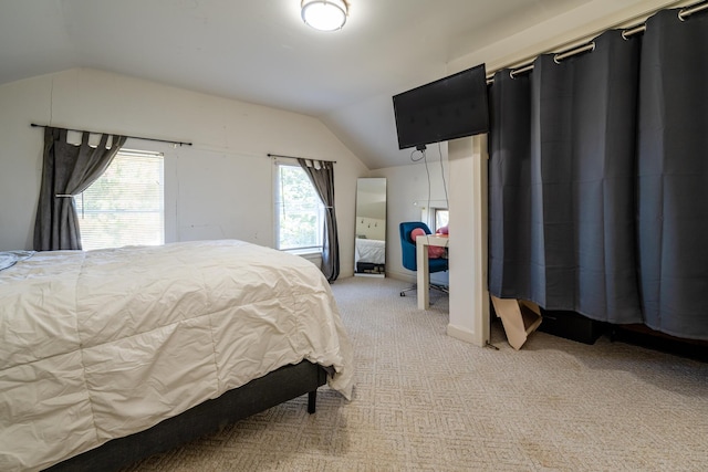 bedroom with vaulted ceiling and light carpet