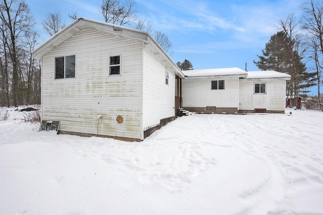 view of snow covered back of property