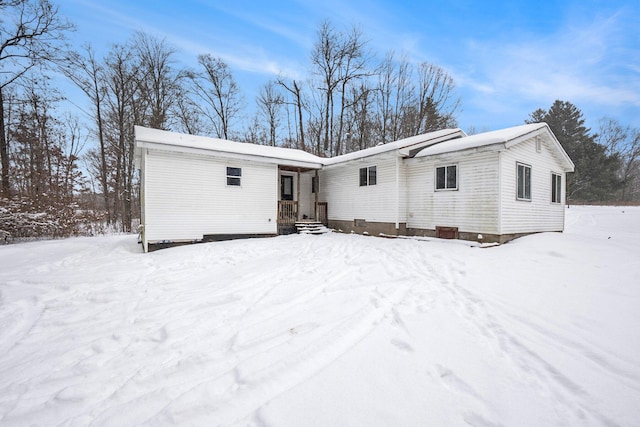 view of snow covered back of property