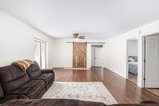living room featuring a barn door and dark hardwood / wood-style floors