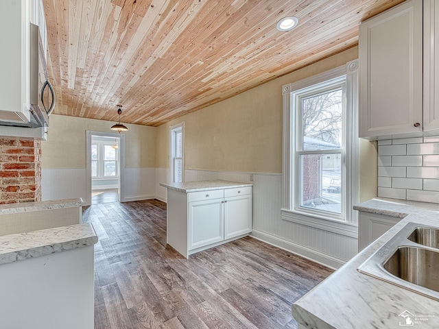 kitchen with wood ceiling, hanging light fixtures, light hardwood / wood-style floors, white cabinets, and decorative backsplash