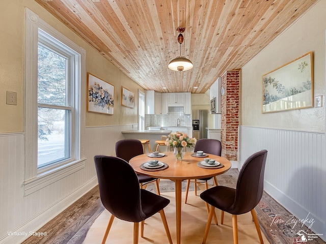 dining area featuring sink, wooden ceiling, and light hardwood / wood-style flooring