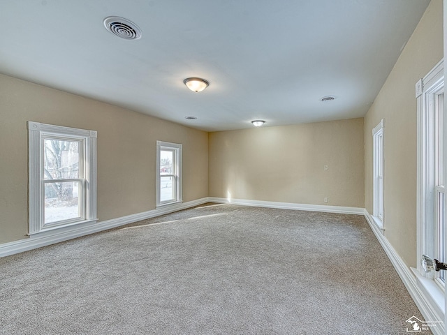 empty room with a healthy amount of sunlight and carpet flooring