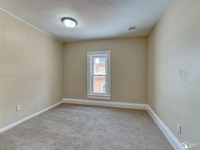 carpeted empty room with a textured ceiling