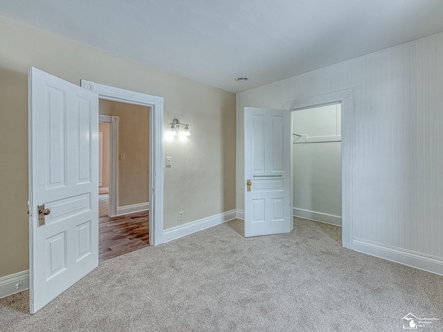 unfurnished bedroom with a closet and light carpet